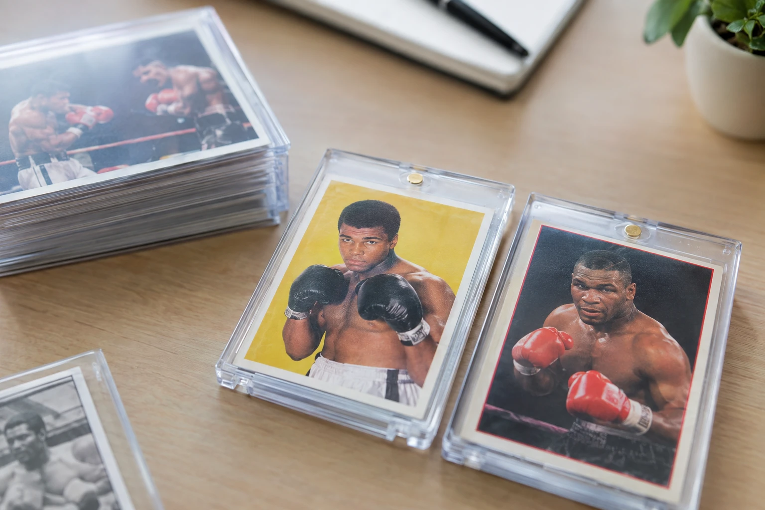 Vintage boxing trading cards featuring Muhammad Ali and Mike Tyson on a collector's desk
