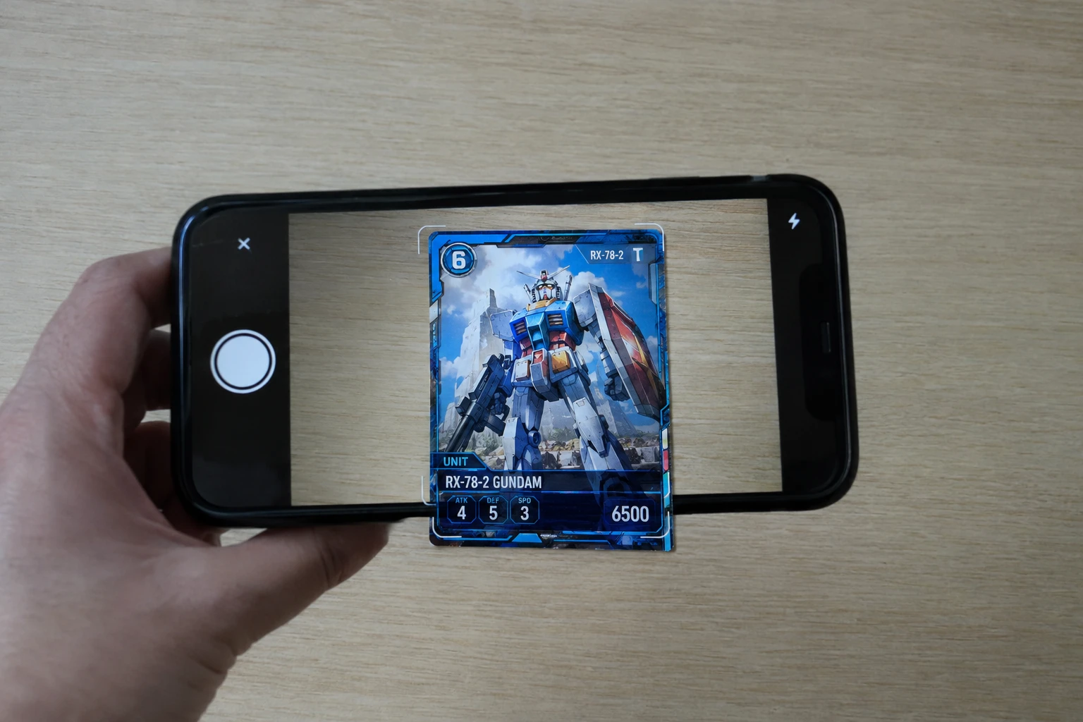 A Gundam Card Game trading card being scanned for AI grading