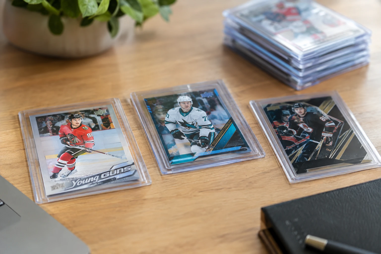 Hockey trading cards featuring Connor Bedard Young Guns, Macklin Celebrini rookie, and Upper Deck Black parallels laid out for AI grading