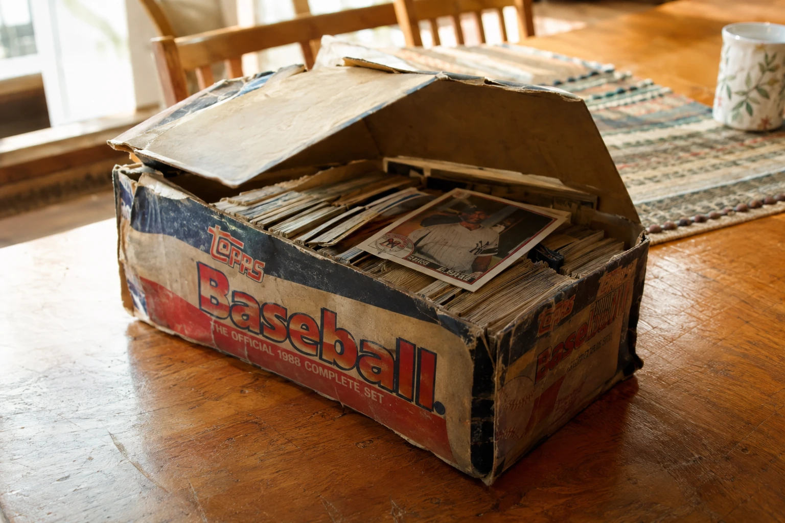 A shoebox of old trading cards on a family kitchen table