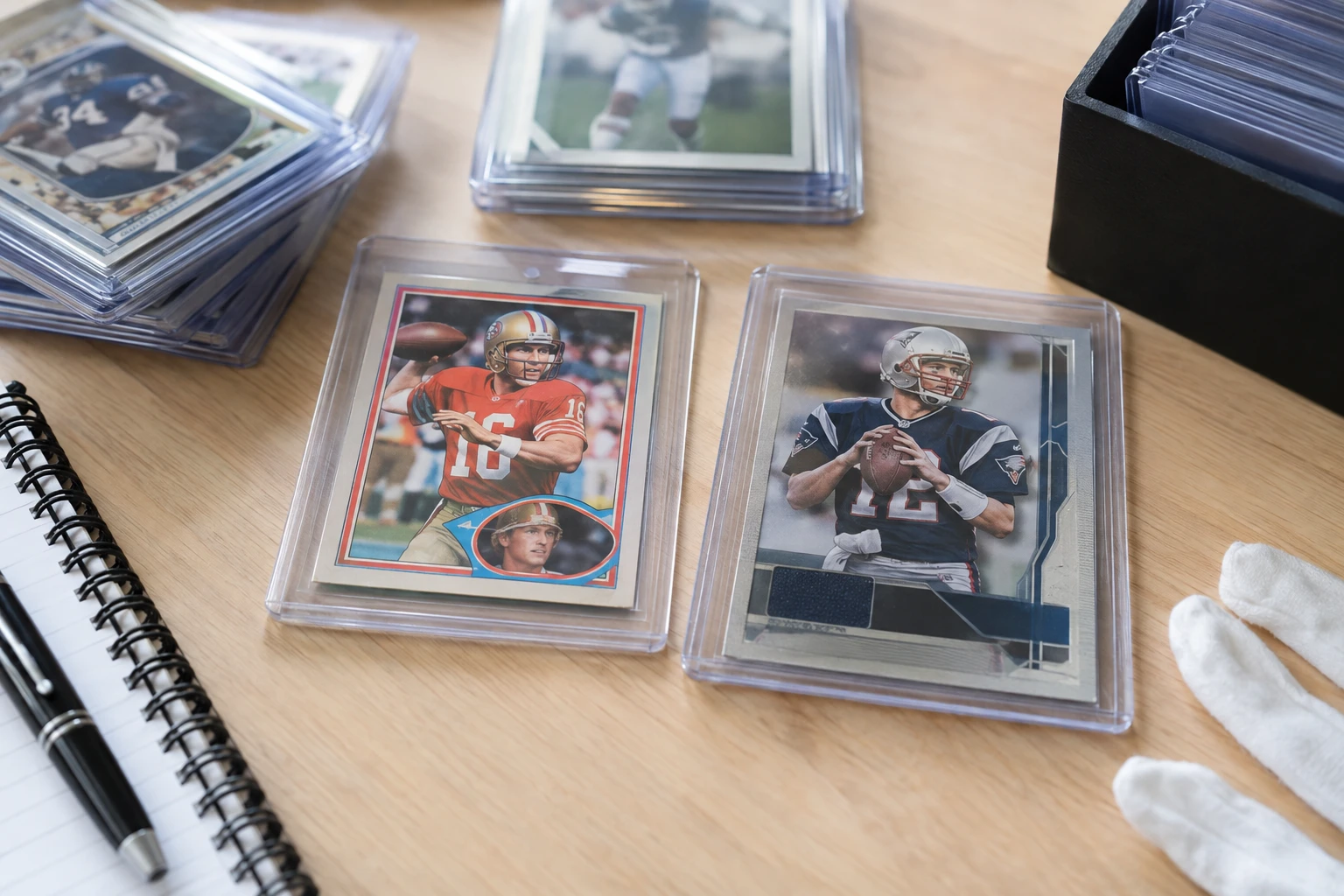 Vintage football cards including 1981 Topps Joe Montana rookie and 2000 Playoff Contenders Tom Brady being examined for PSA grading