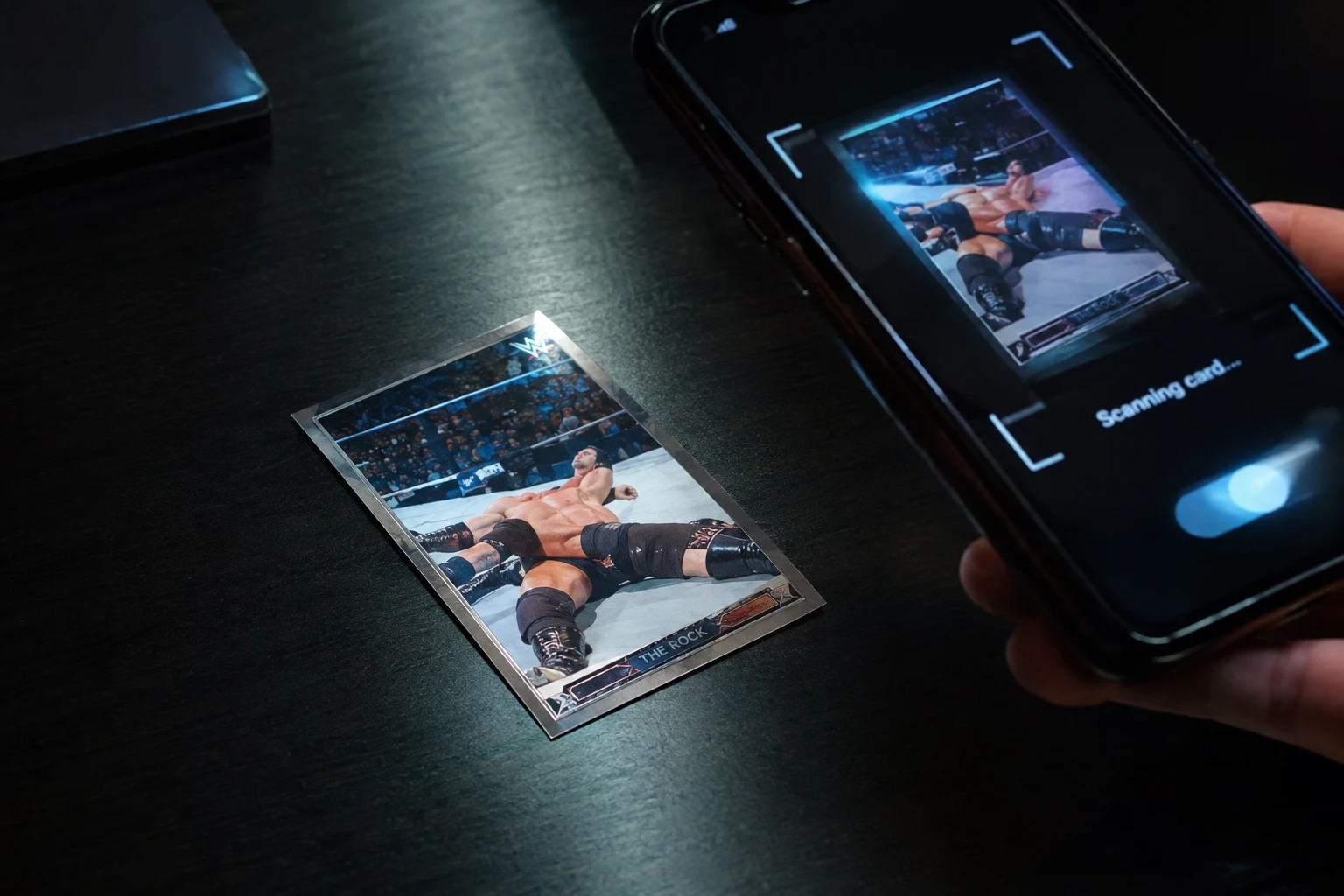 A WWE wrestling trading card being graded by a phone